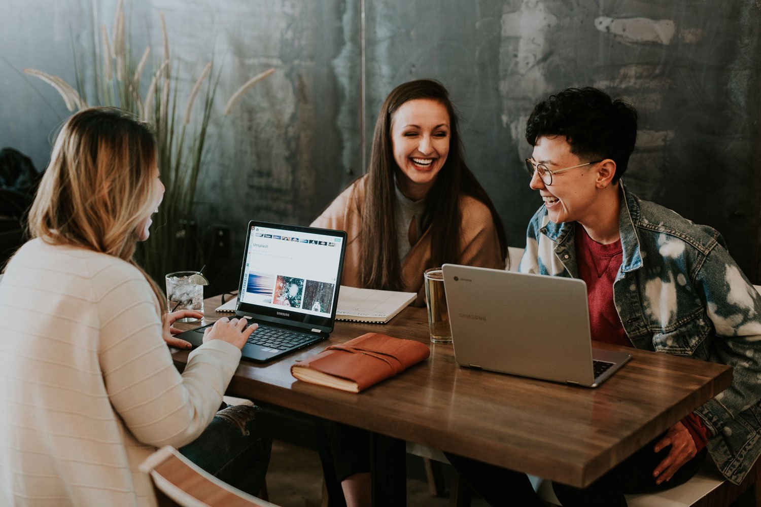 Bild zeigt drei Frauen mit Laptops beim Meeting im Café