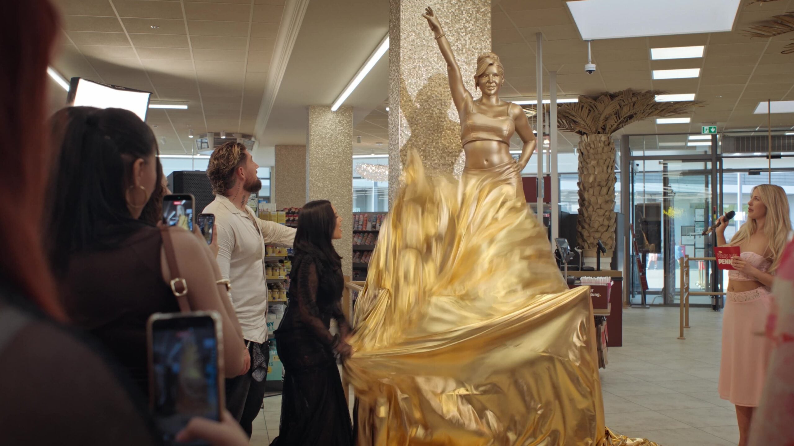Leyla Heiter und ihr Freund enthüllen goldene Statue im PENNY.